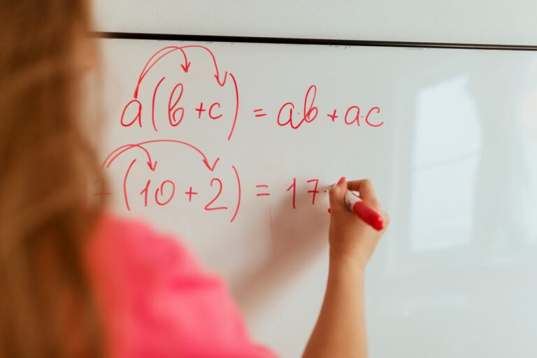 teacher writes math equations on the blackboard